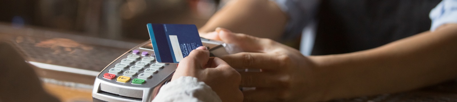 picture of female customer holding debit card near card reader